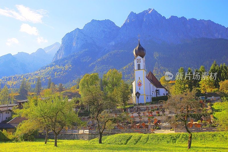 巴洛克式的圣约翰尼斯德尔Täufer教堂在Grainau阿尔卑斯村与Zugspitze, Waxenstein和Alpspitze景观-戏剧性的风景在巴伐利亚阿尔卑斯山，德国，附近的Karwendel山脉-雄伟的高山景观秋天-加尔米施，德国巴伐利亚